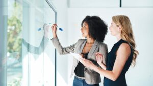 Marketing Glossary blog featured image-women writing on board
