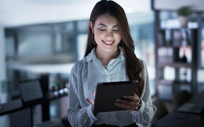 shot of a young businesswoman using a digital tablet in an office at night.jpg